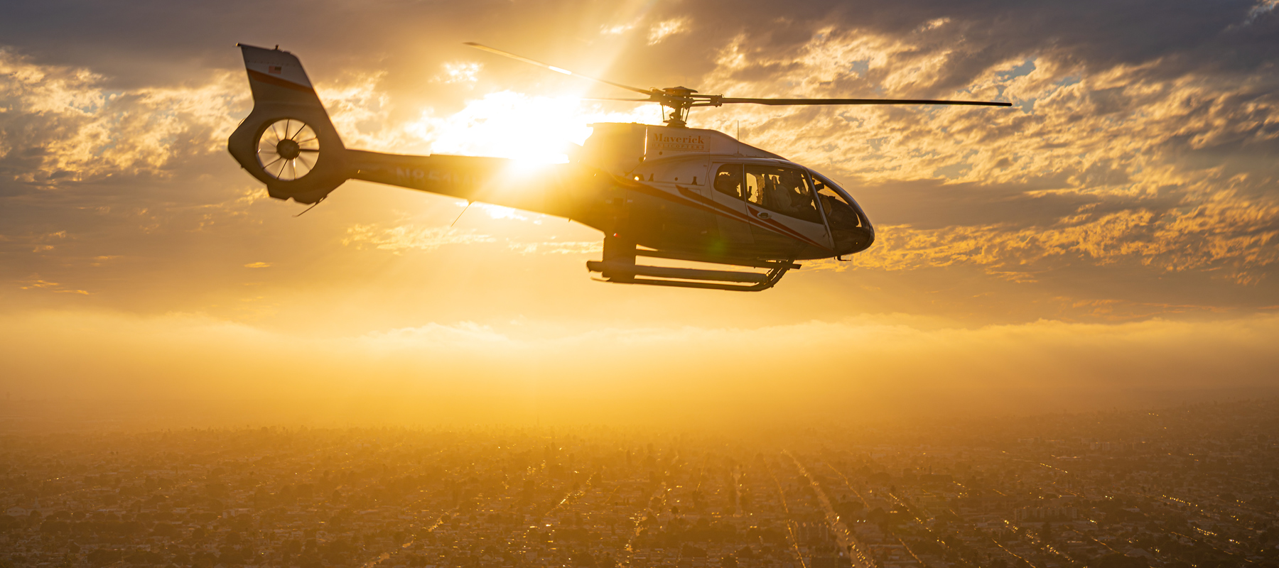 Maverick helicopter soaring above Los Angeles during the golden hour