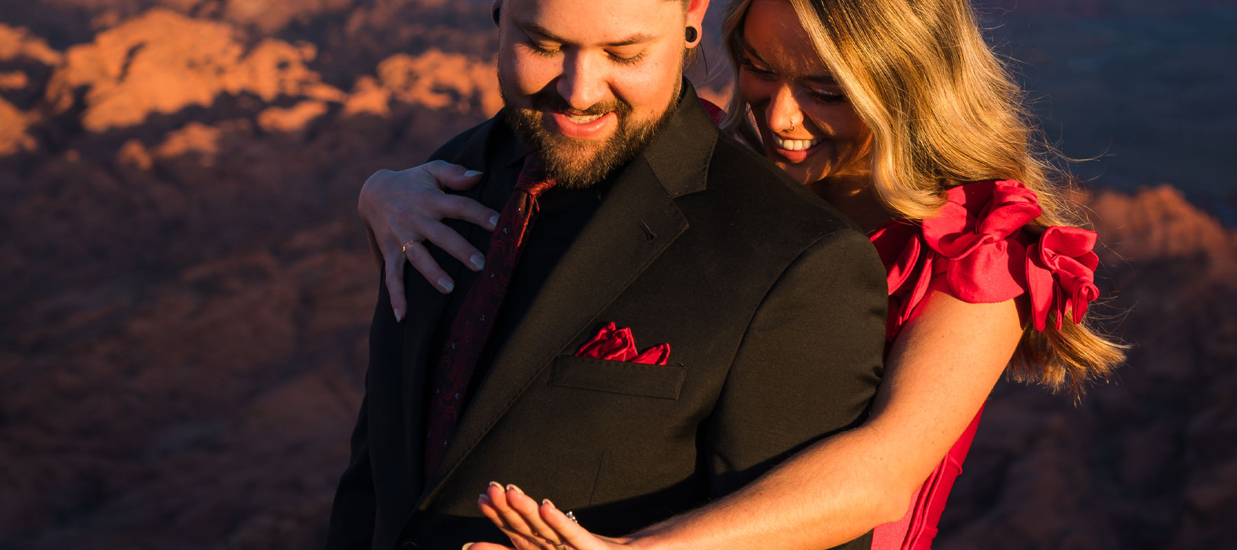 Newly engaged couple embracing with a stunning desert sunset at Valley of Fire