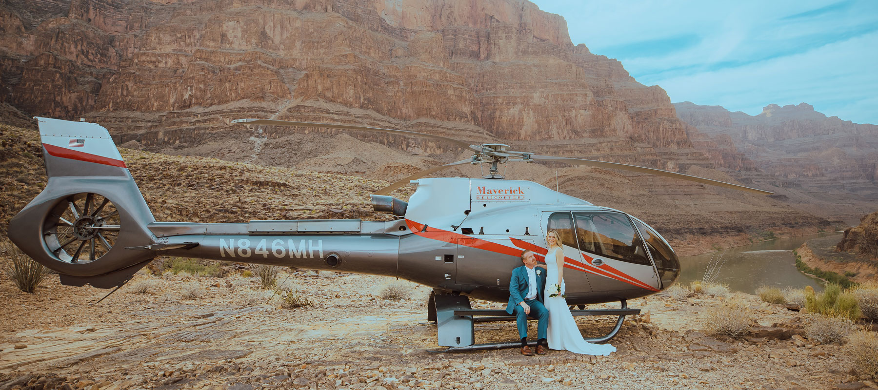 Couple posing together with the Grand Canyon landscape stretching behind them