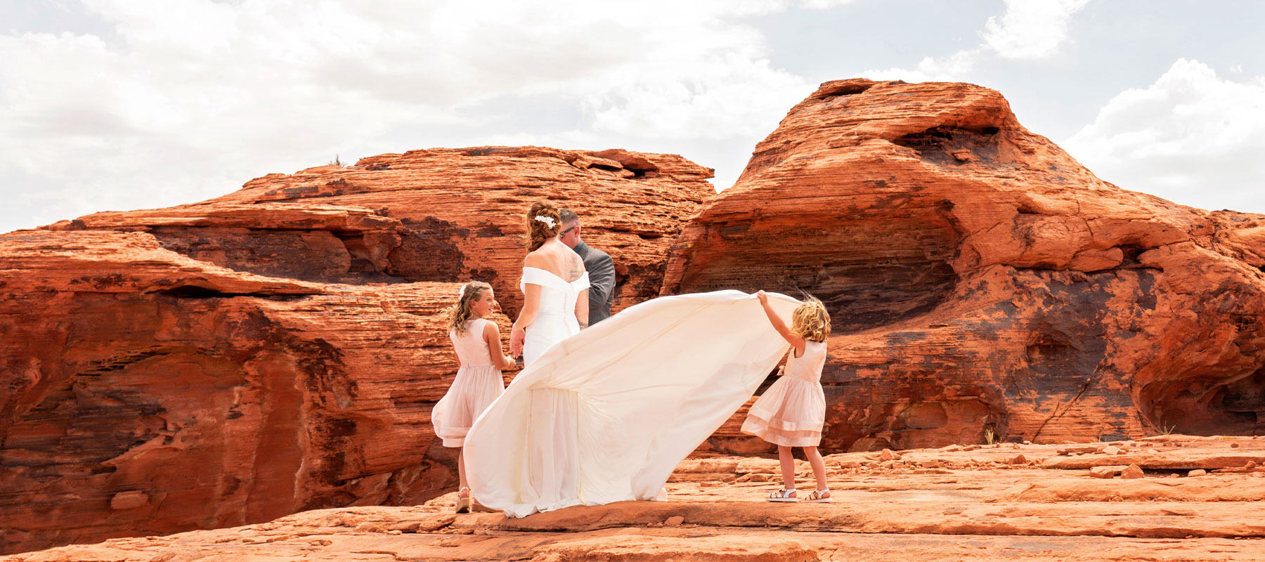 Wide panoramic view of a wedding couple surrounded by Valley of Fire red rock formations